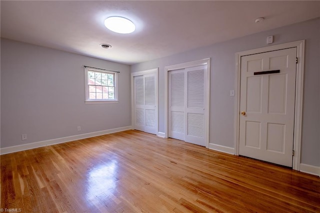 3230 Kinnamon Rd, Winston-Salem, NC 27104 - unfurnished bedroom with light wood-type flooring, baseboards, visible vents, and two closets