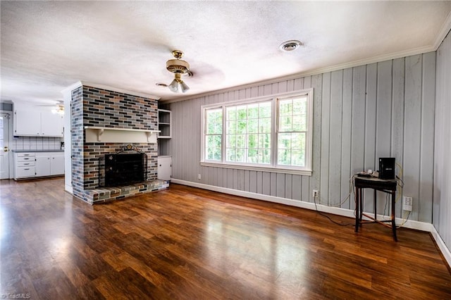 3230 Kinnamon Rd, Winston-Salem, NC 27104 - unfurnished living room featuring wood finished floors, a ceiling fan, a brick fireplace, visible vents, and baseboards