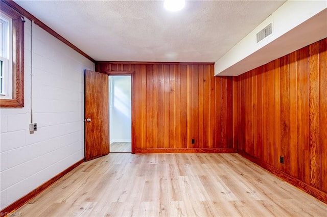 3230 Kinnamon Rd, Winston-Salem, NC 27104 - spare room featuring visible vents, light wood-style flooring, baseboards, and wooden walls