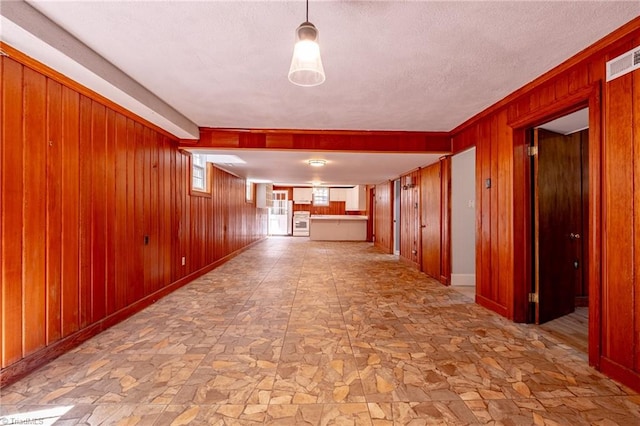 3230 Kinnamon Rd, Winston-Salem, NC 27104 - corridor featuring a textured ceiling, wood walls, stone finish flooring, and visible vents