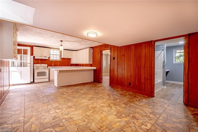 3230 Kinnamon Rd, Winston-Salem, NC 27104 - kitchen featuring a peninsula, stone finish floor, electric range, white cabinets, and wood walls