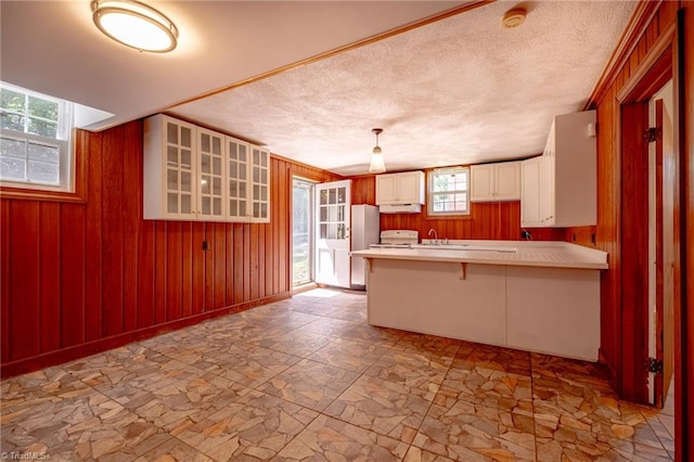 3230 Kinnamon Rd, Winston-Salem, NC 27104 - kitchen with a peninsula, a breakfast bar area, stone finish flooring, light countertops, and wooden walls
