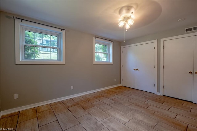 3230 Kinnamon Rd, Winston-Salem, NC 27104 - unfurnished bedroom with baseboards, visible vents, and two closets