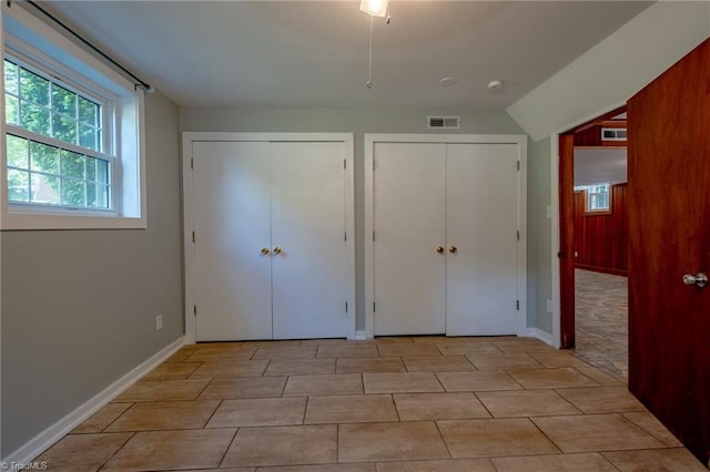3230 Kinnamon Rd, Winston-Salem, NC 27104 - unfurnished bedroom with two closets, lofted ceiling, baseboards, and visible vents