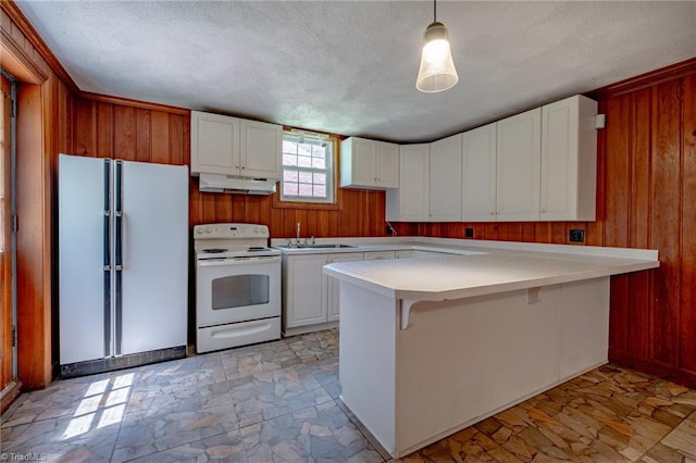 3230 Kinnamon Rd, Winston-Salem, NC 27104 - kitchen featuring white appliances, wooden walls, light countertops, and a sink