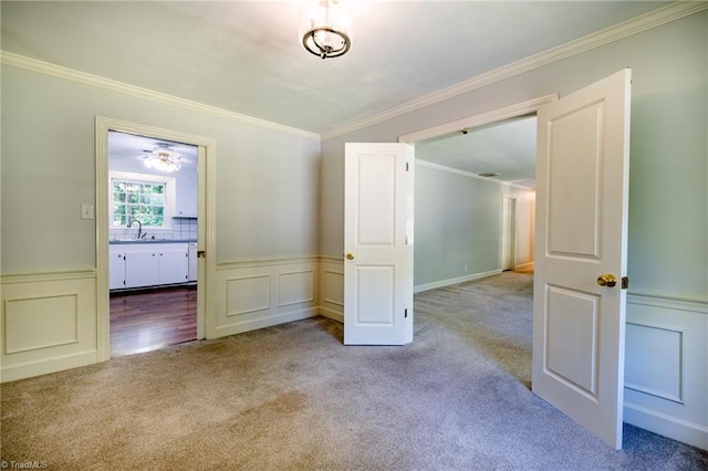 3230 Kinnamon Rd, Winston-Salem, NC 27104 - empty room with a sink, a decorative wall, ornamental molding, carpet flooring, and wainscoting