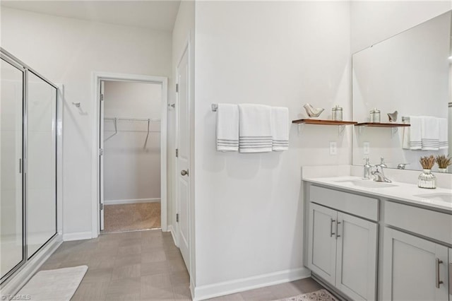 162 Bryson Blvd, Lexington, NC 27295 - bathroom featuring a stall shower, double vanity, a spacious closet, and tile patterned floors