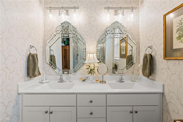 bathroom with double vanity, wallpapered walls, and a sink