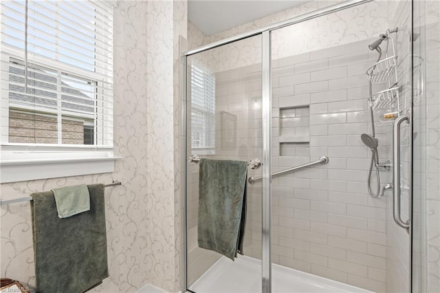 bathroom featuring wallpapered walls and a stall shower