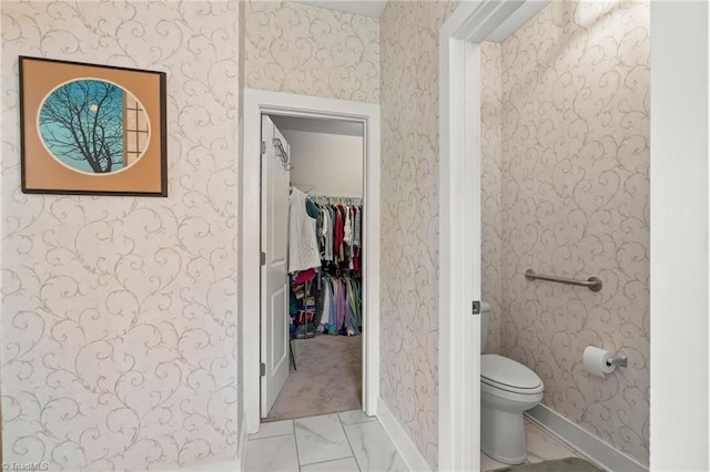 bathroom featuring wallpapered walls, toilet, baseboards, and marble finish floor