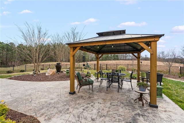 view of patio / terrace with a gazebo, outdoor dining area, and fence