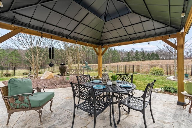 view of patio / terrace featuring a gazebo, outdoor dining area, and fence