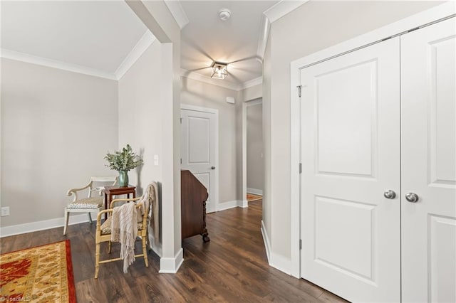 hallway featuring dark wood finished floors, crown molding, and baseboards