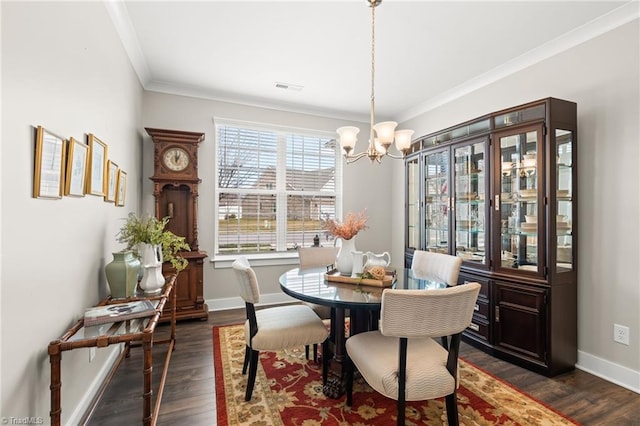 dining room featuring dark wood finished floors, visible vents, an inviting chandelier, and ornamental molding