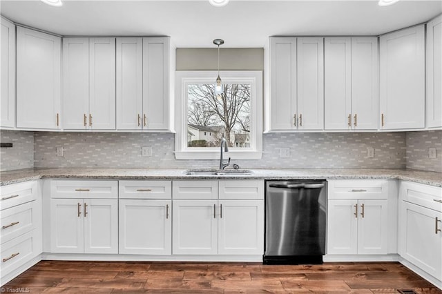 kitchen featuring a sink, stainless steel dishwasher, dark wood-style flooring, and hanging light fixtures