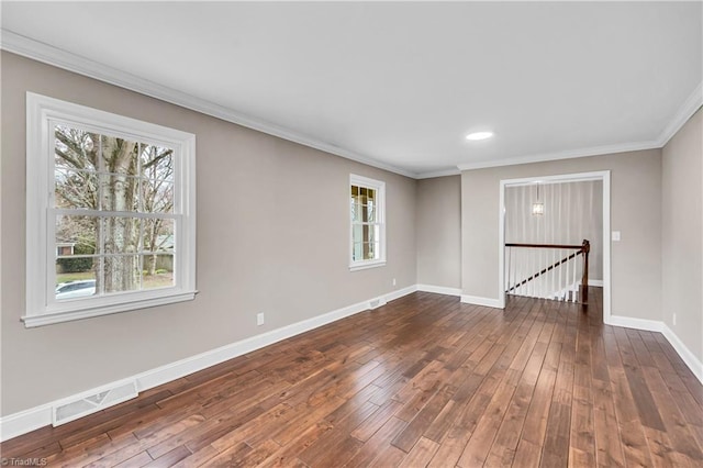 empty room featuring crown molding, baseboards, visible vents, and dark wood-style flooring