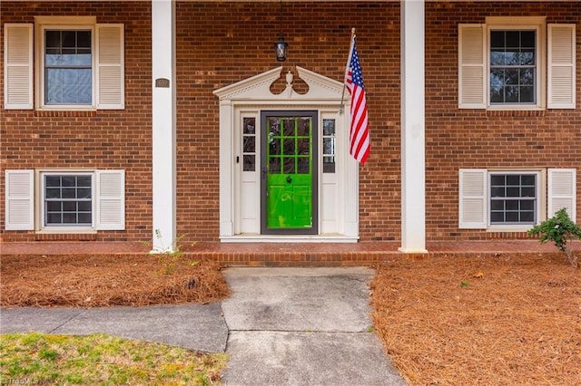 entrance to property featuring brick siding