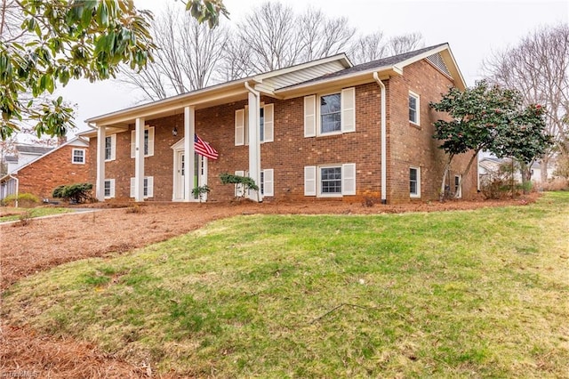 view of front of home featuring brick siding and a front yard