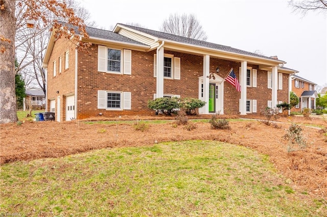 bi-level home with a front yard, an attached garage, and brick siding