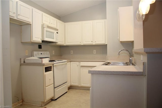 kitchen with white appliances, white cabinetry, and hanging light fixtures