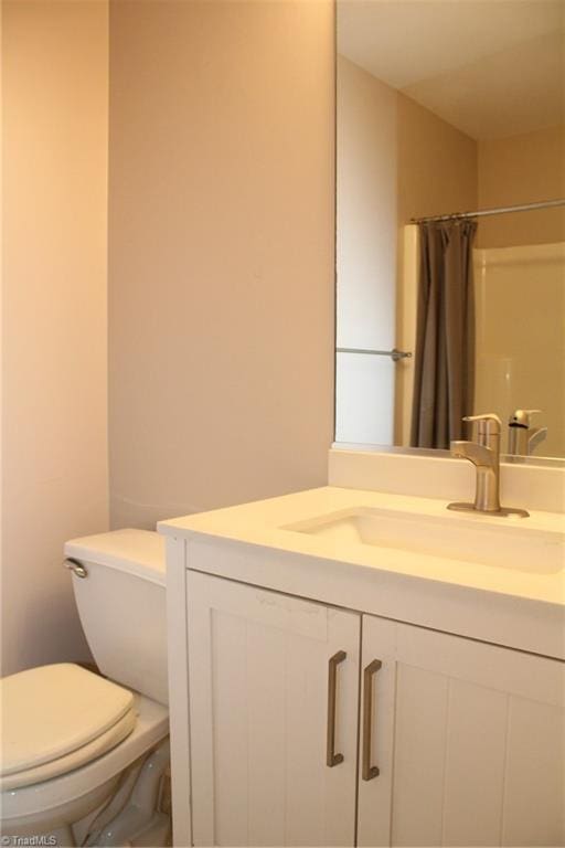 bathroom with toilet, a shower with shower curtain, and vanity