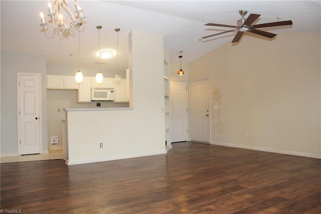 unfurnished living room featuring lofted ceiling, ceiling fan with notable chandelier, and dark wood-type flooring