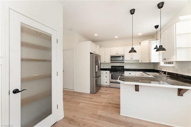 kitchen featuring a breakfast bar, a peninsula, open shelves, a sink, and appliances with stainless steel finishes