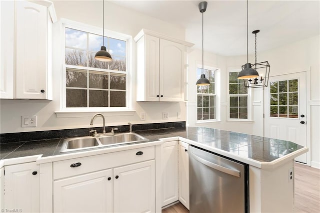 kitchen featuring a peninsula, a sink, tile counters, pendant lighting, and stainless steel dishwasher