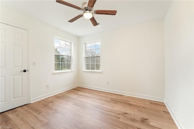 spare room with ceiling fan, baseboards, and light wood-style floors