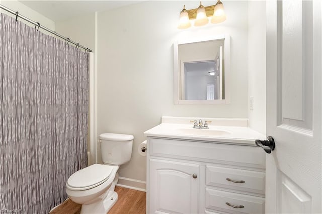 bathroom featuring vanity, a shower with curtain, wood finished floors, baseboards, and toilet