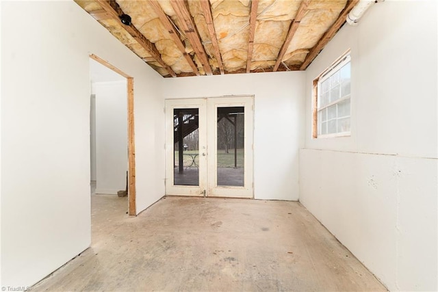 empty room featuring french doors and concrete flooring