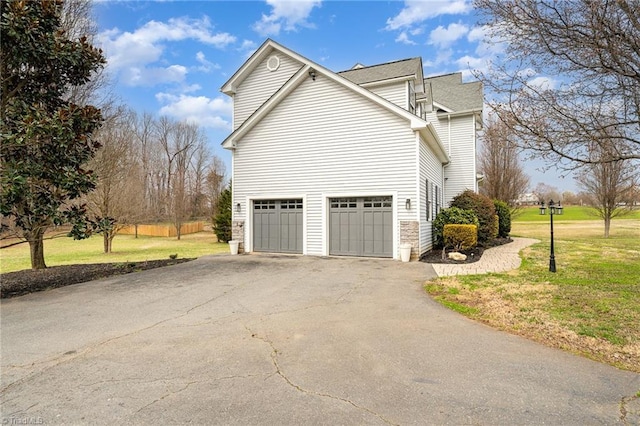 view of side of home featuring a lawn and driveway