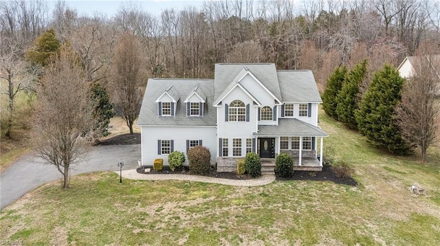 traditional-style home with driveway and a front lawn