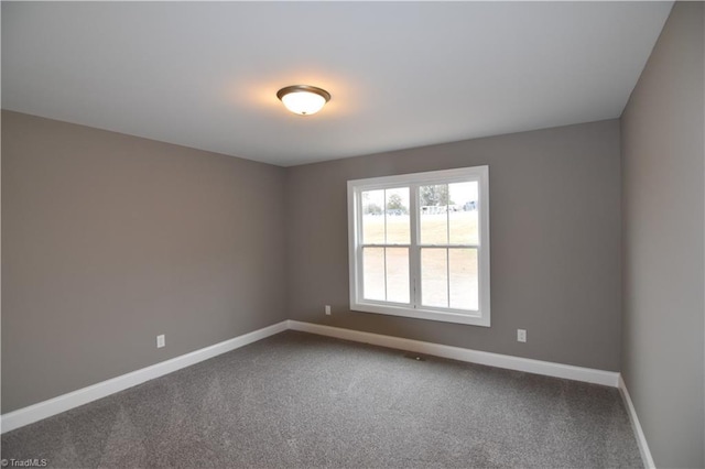 empty room featuring carpet flooring and baseboards