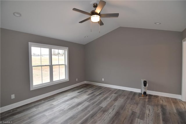 empty room featuring a ceiling fan, lofted ceiling, baseboards, and wood finished floors