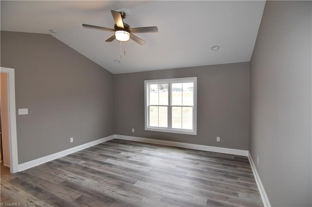 unfurnished room with lofted ceiling, wood finished floors, a ceiling fan, and baseboards