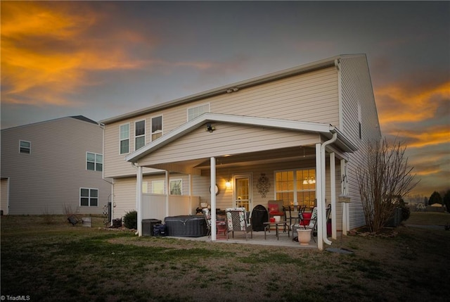 back of property at dusk featuring a patio