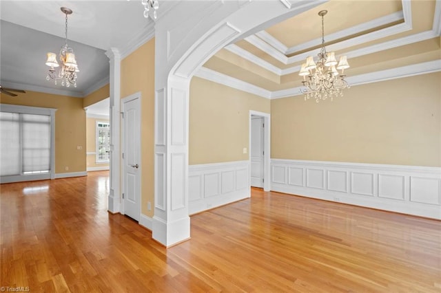5080 Century Oaks Ln, Winston-Salem, NC 27106 - spare room featuring a chandelier, arched walkways, ornamental molding, light wood-style floors, and a tray ceiling