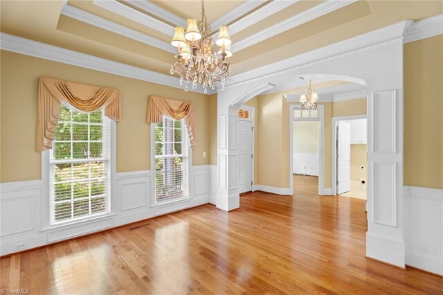 5080 Century Oaks Ln, Winston-Salem, NC 27106 - unfurnished dining area featuring a chandelier, arched walkways, crown molding, a wainscoted wall, and a raised ceiling