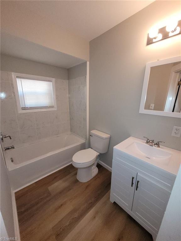 full bathroom featuring shower / bathing tub combination, vanity, toilet, baseboards, and wood finished floors