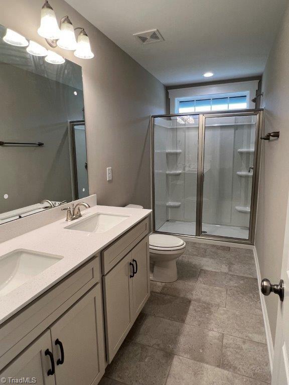 bathroom featuring walk in shower, vanity, and toilet