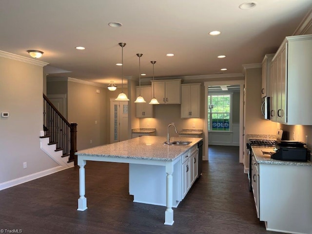 kitchen with dark hardwood / wood-style flooring, sink, an island with sink, pendant lighting, and appliances with stainless steel finishes