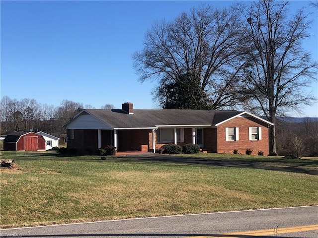 single story home with a storage shed and a front yard