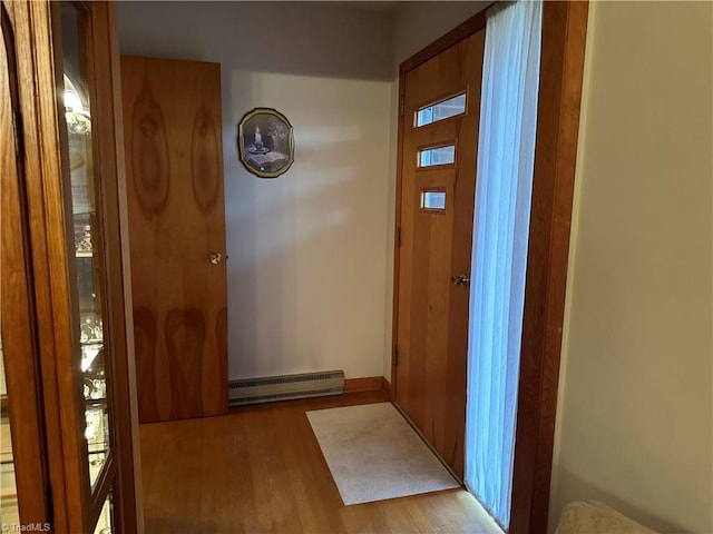 doorway featuring baseboard heating and light hardwood / wood-style flooring