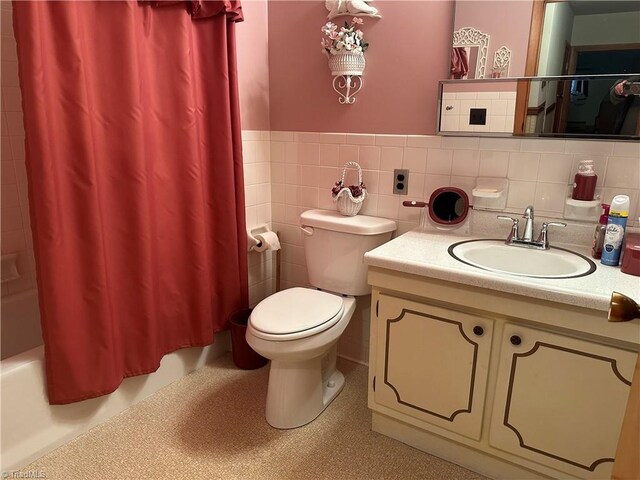 full bathroom featuring toilet, vanity, shower / tub combo with curtain, and tile walls