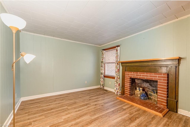 unfurnished living room with a brick fireplace, crown molding, and hardwood / wood-style floors