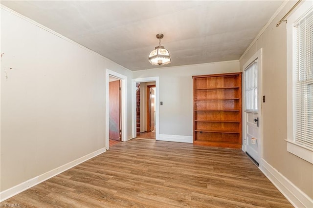 empty room with hardwood / wood-style flooring and ornamental molding