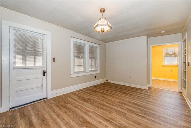 entryway with crown molding and wood-type flooring