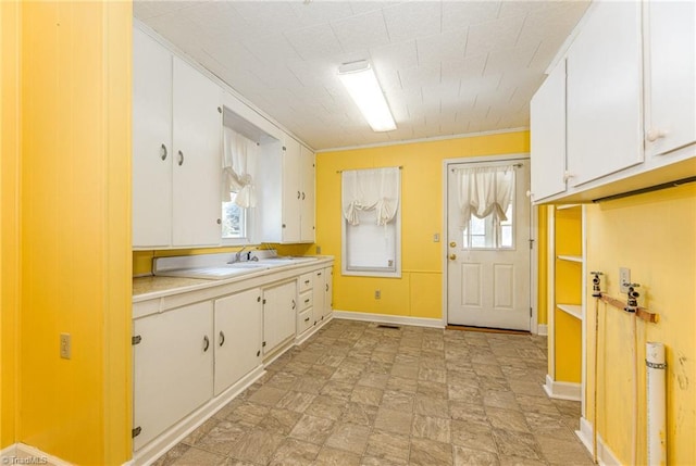 kitchen featuring white cabinetry and sink