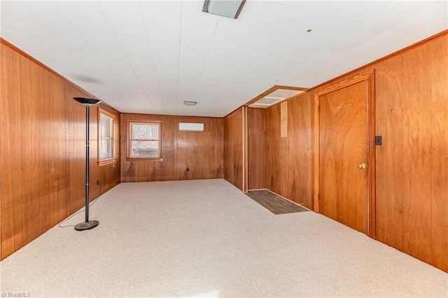 empty room featuring carpet flooring and wood walls